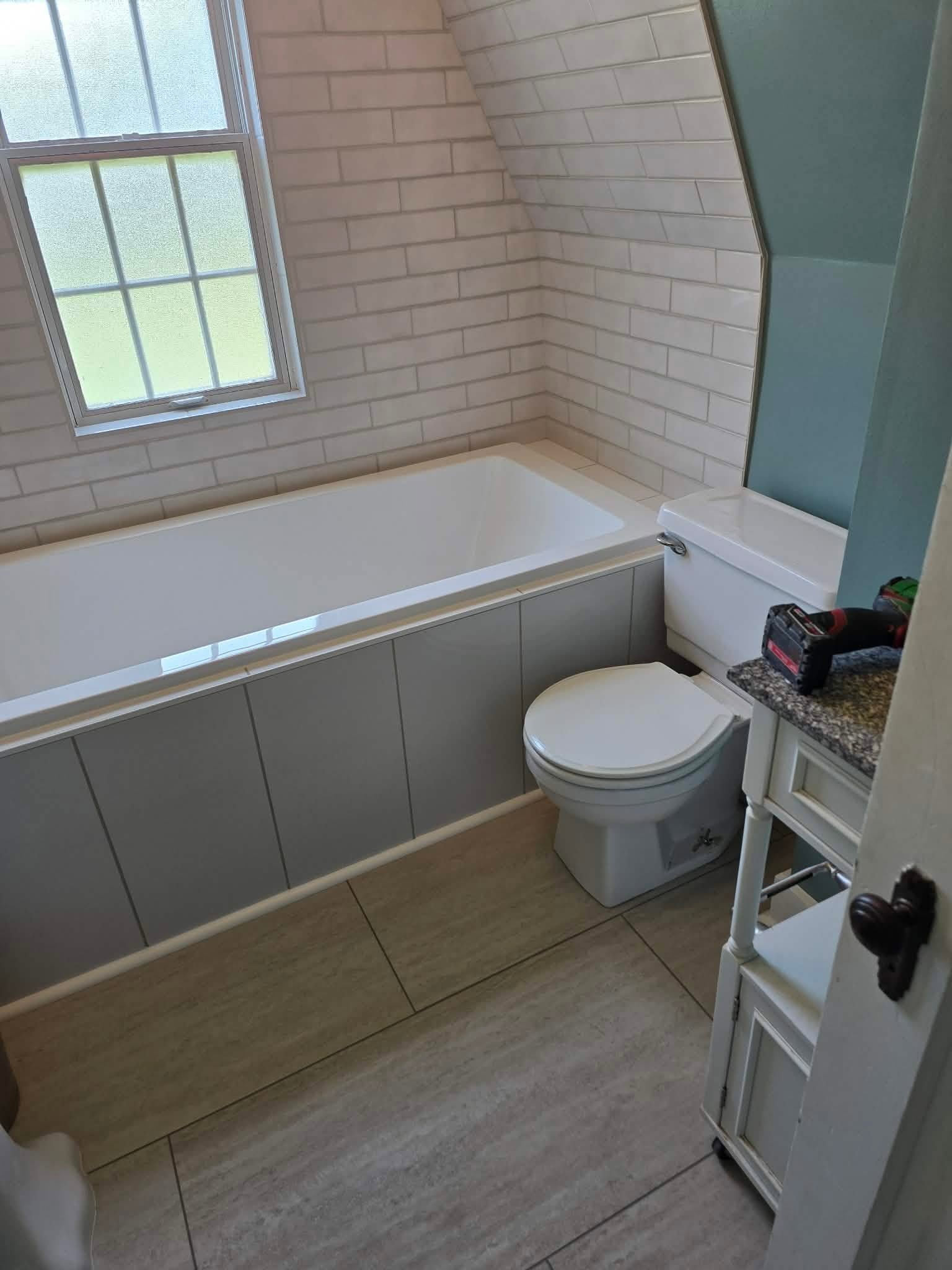 Bathroom remodel with tiled tub surround and updated finishes