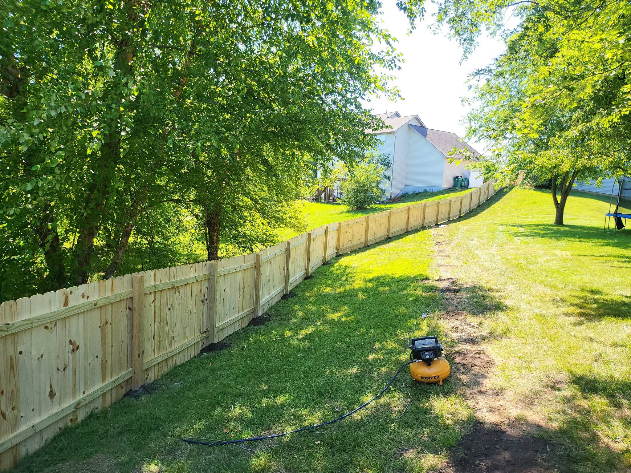 New wood privacy fence installed along a residential backyard